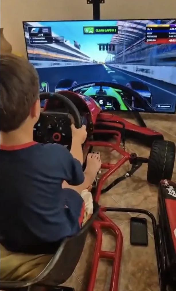 A child driving the kart simulator in a living room